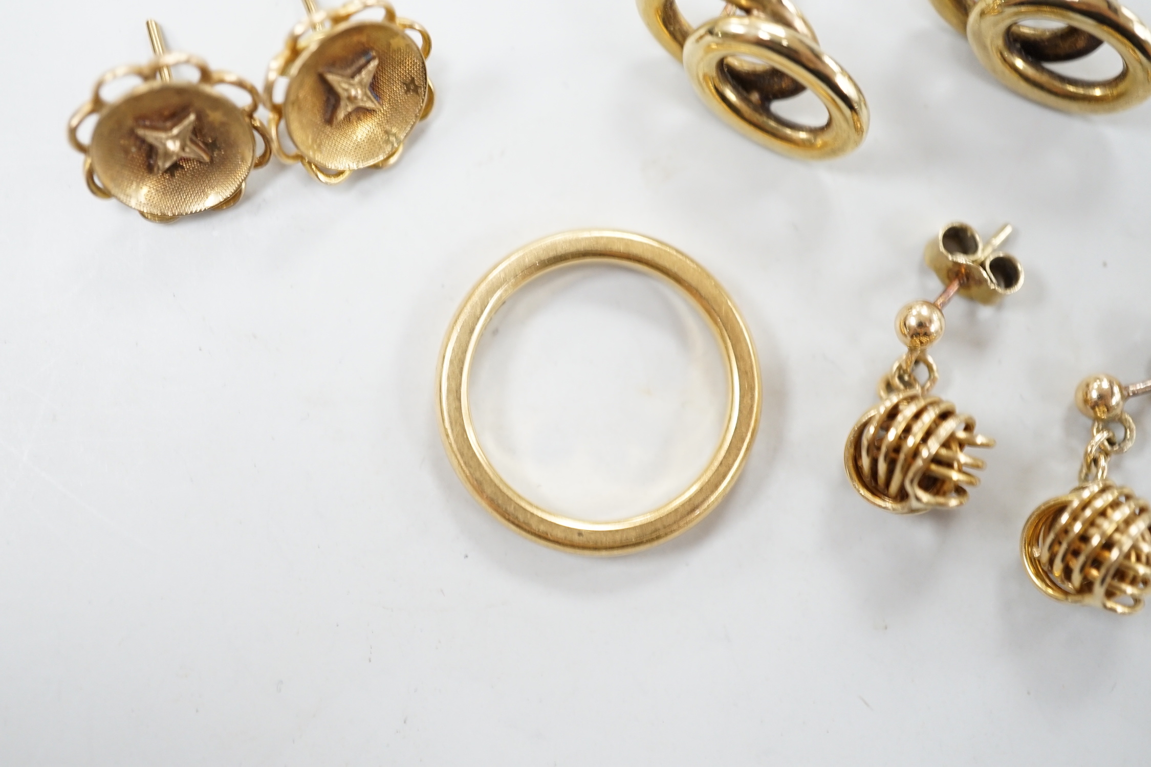 An 18ct gold wedding band, size L/M, 5.2 grams and three pairs of yellow metal earrings.